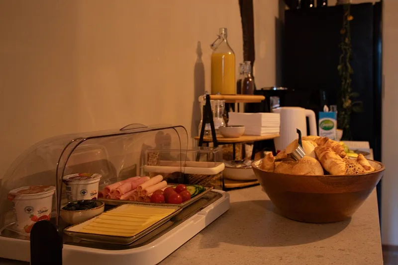 Het ontbijtbuffet van Bnb 1691: kaas, vleeswaren, yoghurt, verse jus en een mand met broodjes