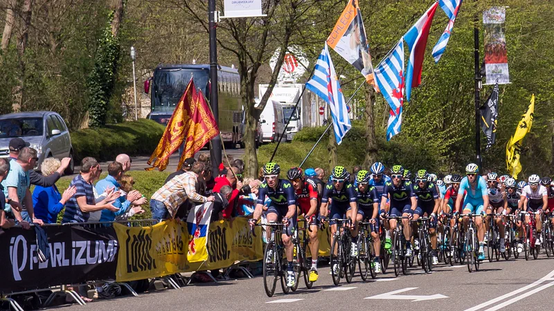 Het peloton van de Amstel Gold Race klimt de Cauberg op, langs juichend publiek met vlaggen